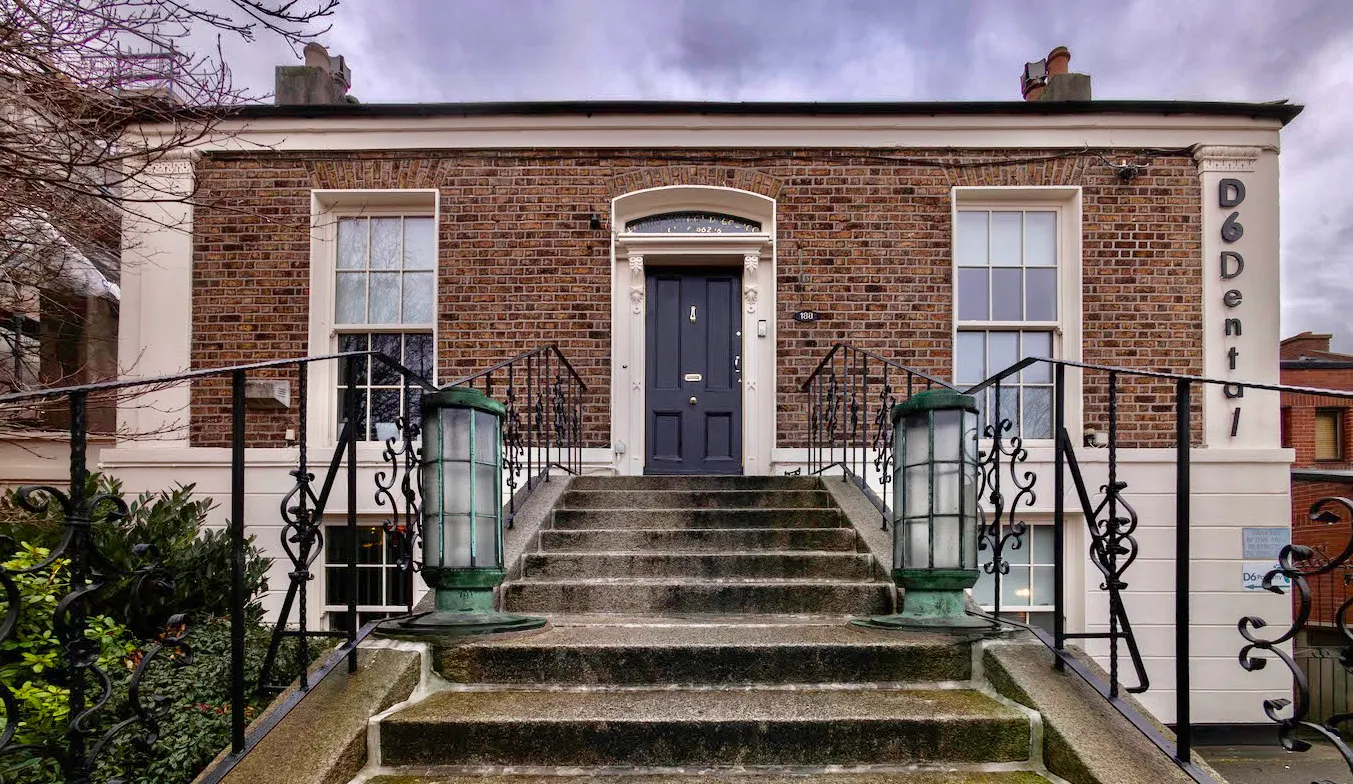 D6 Dental (Connellan & Associates), Dublin, Co. Dublin: Front exterior of the D6 Dental Georgian brick building with granite steps, black railings, navy front door and 'D6 Dental' signage on the pillar.